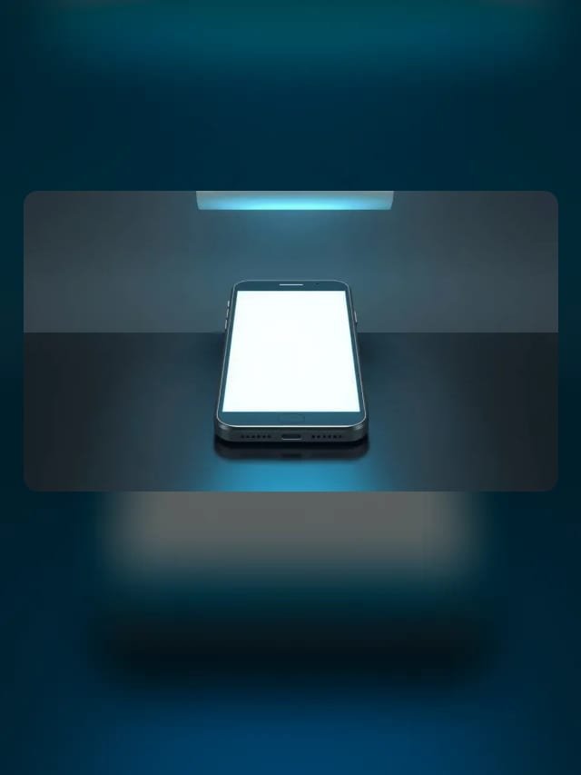 Celular com tela em branco iluminada por uma faixa de luz ciano sobre uma superfície escura