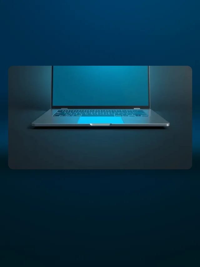Laptop metálica delgada abierta con pantalla en blanco que brilla en cian sobre fondo grafito